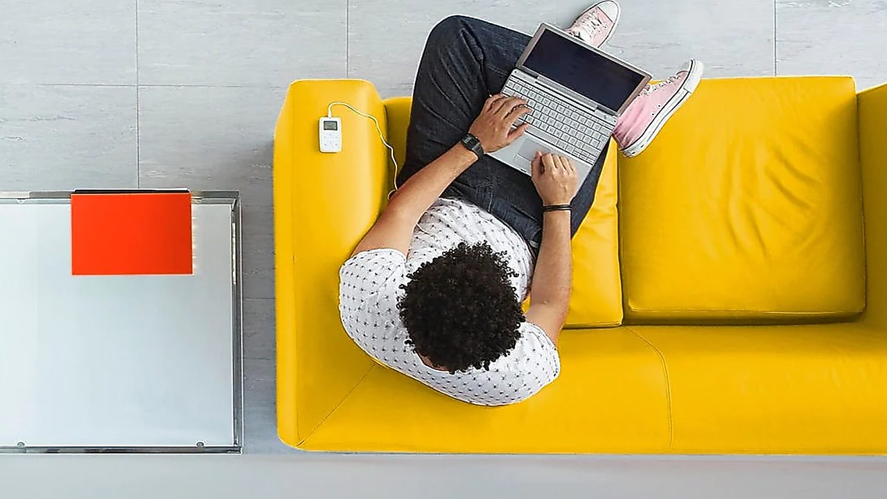 A man sitting on a sofa with his laptop