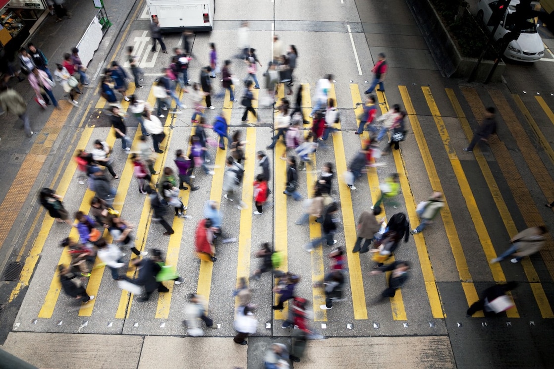Hong Kong'da işlek bir caddeden karşıya geçen insanlar