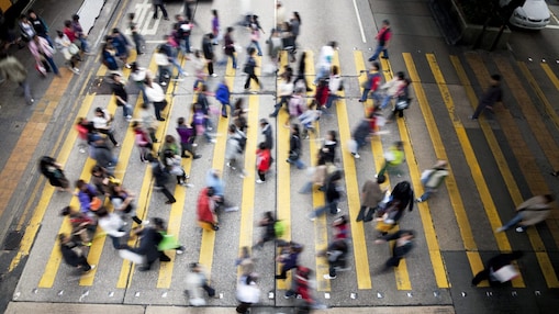 Hong Kong'da işlek bir caddeden karşıya geçen insanlar