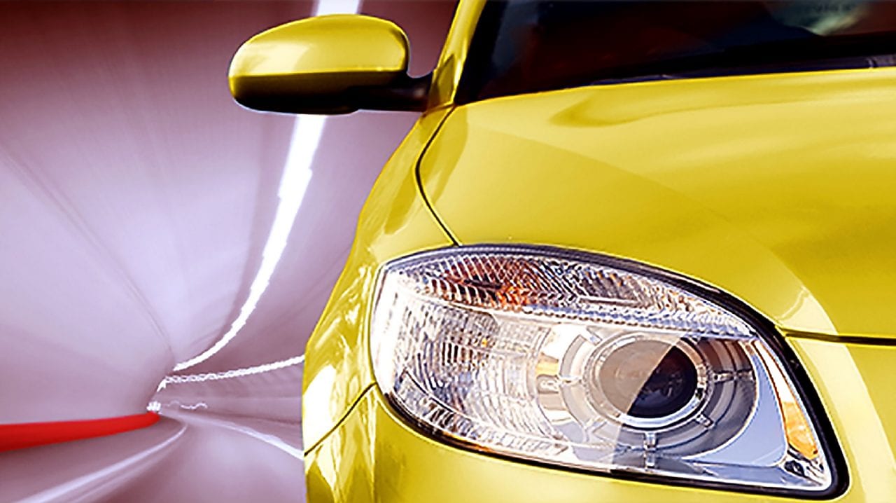 Bir tünelden geçen sarı bir otomobilin önden görüntüsü, sağ ön far ve yan ayna görüntüde