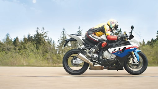 Bir adam taşra yolunda motosiklet kullanıyor