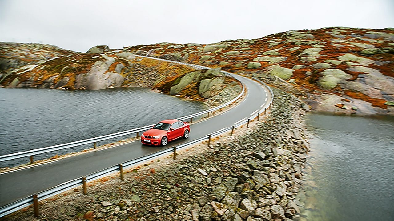 Nehir kenarında bir yolda kırmızı otomobil