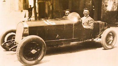 Enzo Ferrari ilk Ferrari otomobillerinden birinde otururken çekilmiş siyah beyaz fotoğraf