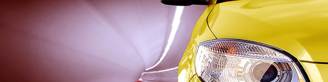 Bir tünelden geçen sarı bir otomobilin önden görüntüsü, sağ ön far ve yan ayna görüntüde