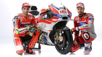 İki Ducati 2016 yarışçısı bir Ducati motosikletinin yanında oturuyor