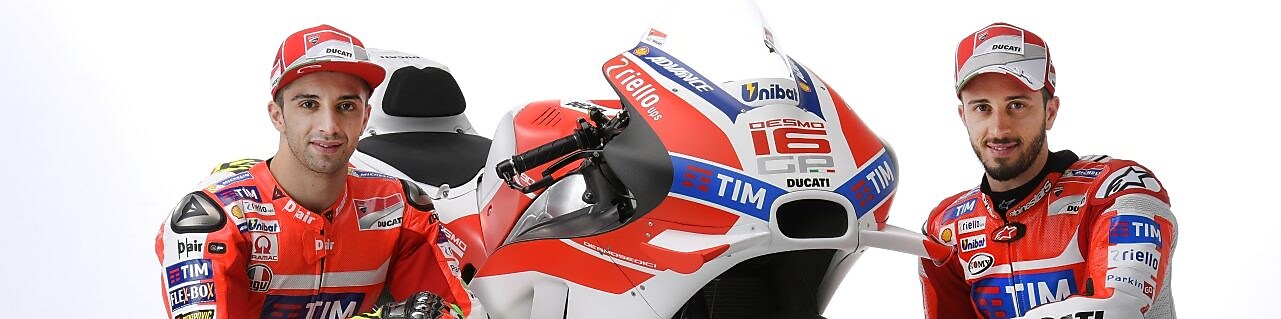 İki Ducati 2016 yarışçısı bir Ducati motosikletinin yanında oturuyor