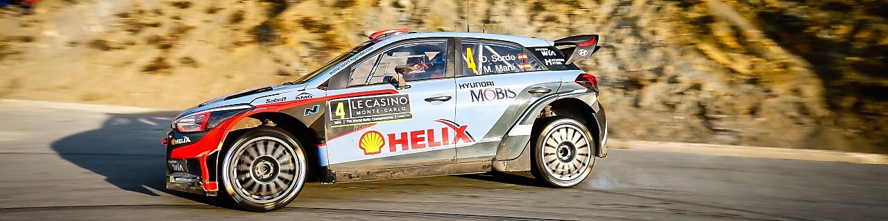 Ralli otomobili dünya ralli şampiyonasında bir köşeden drift yaparak dönüyor