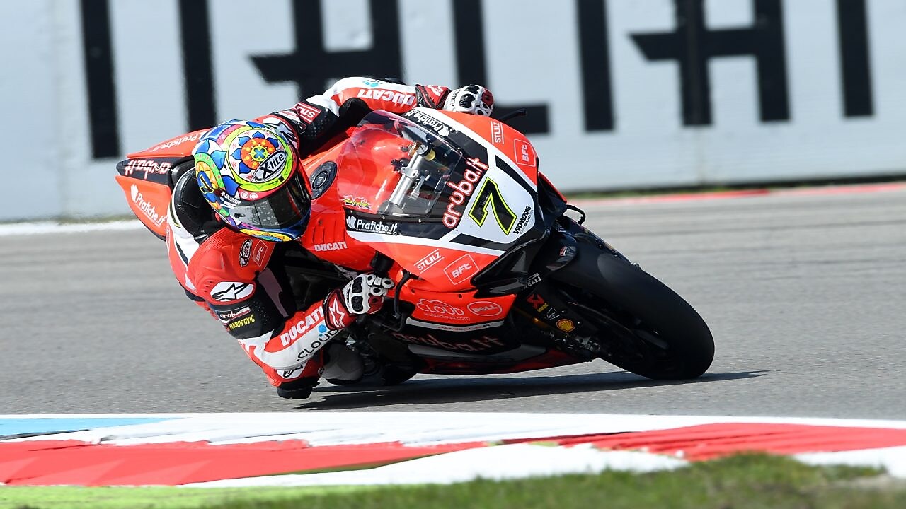 Ducati superbike ve sürücüsü yarış pistinde köşeyi dönüyorlar