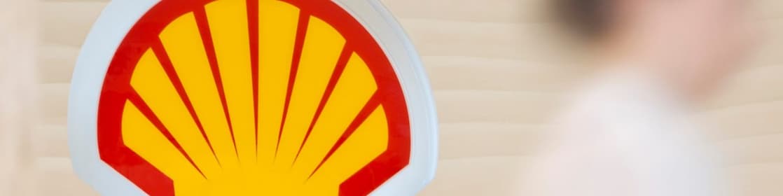 Shell sign with employee climbing steps in the background