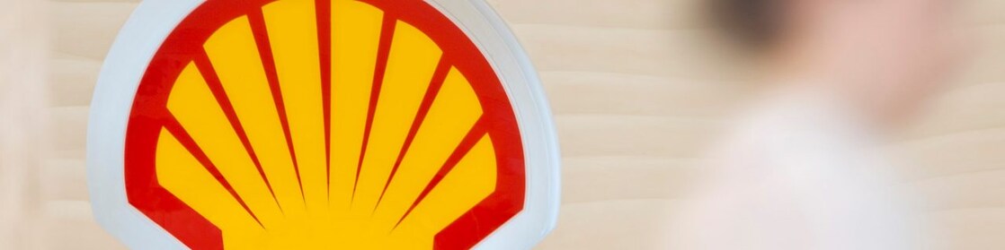 Shell sign with employee climbing steps in the background