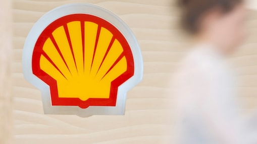 Shell sign with employee climbing steps in the background