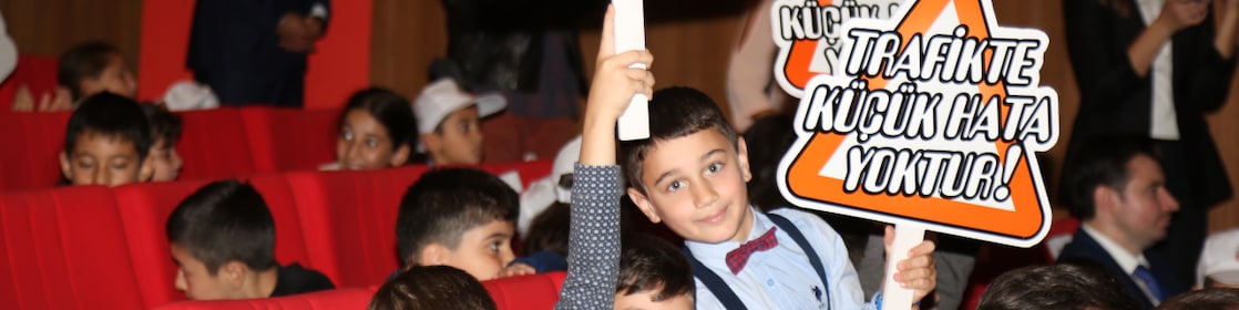 Kids holding placards with the name of the Road Safety project on it